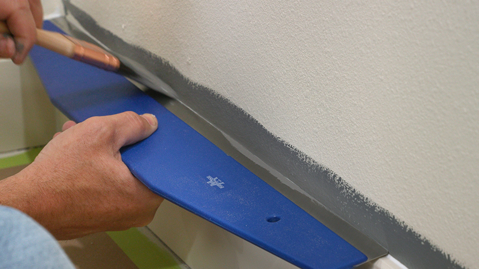 the trim guide tool helps you paint the edge of the wall while keeping the baseboard clean